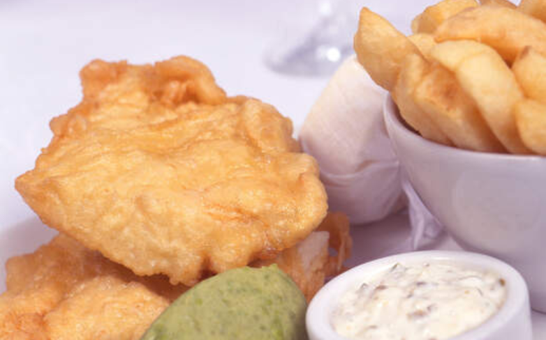 Fish and Chips serviert auf einem Teller mit Dipps
