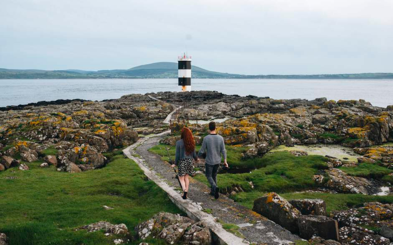 Ein Paar auf Entdeckungstour auf Rathlin Island mit Aussicht auf den Leuchtturm